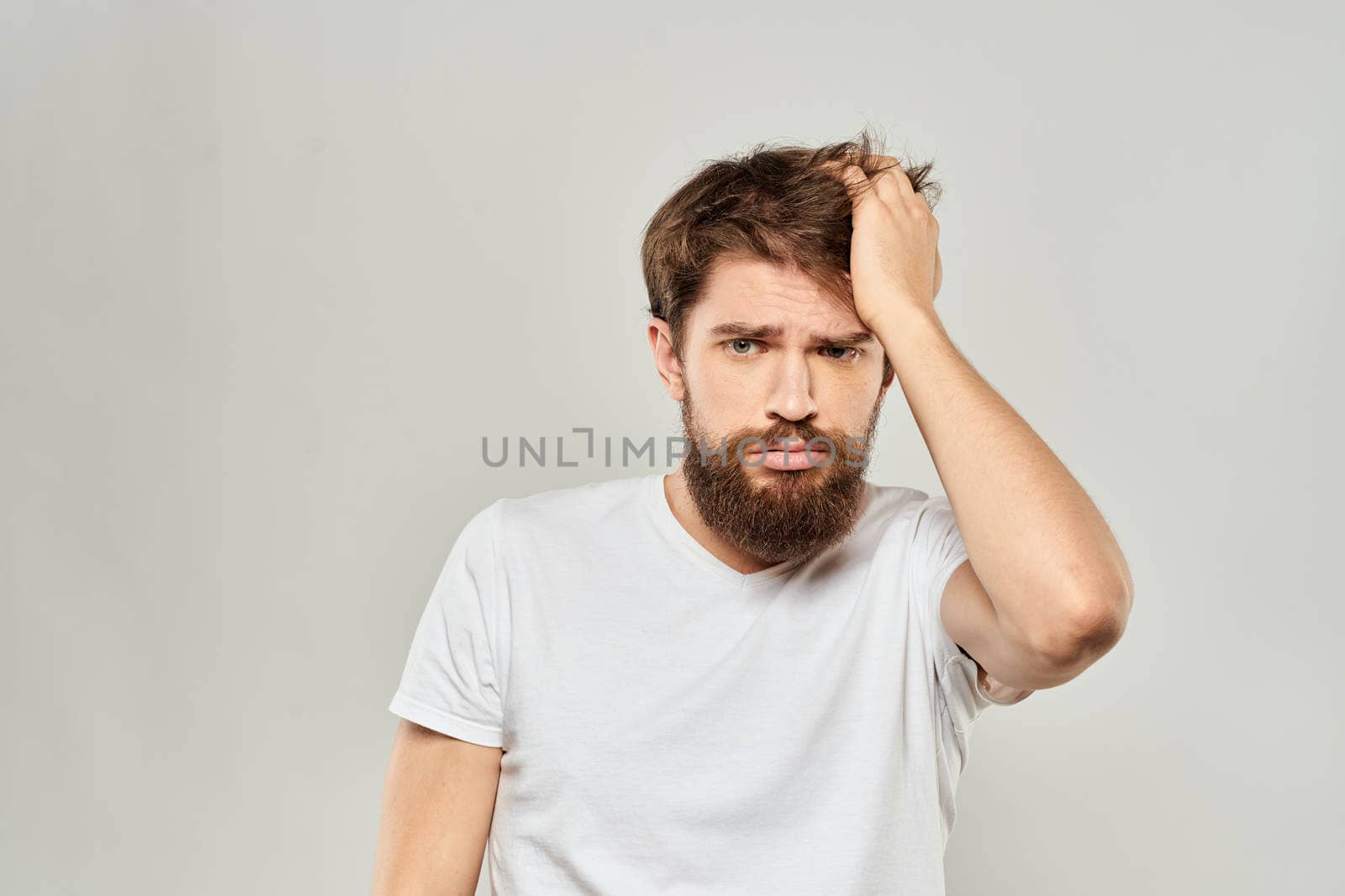 man in white t-shirt gesturing with his hands studio dissatisfaction lifestyle light background by SHOTPRIME