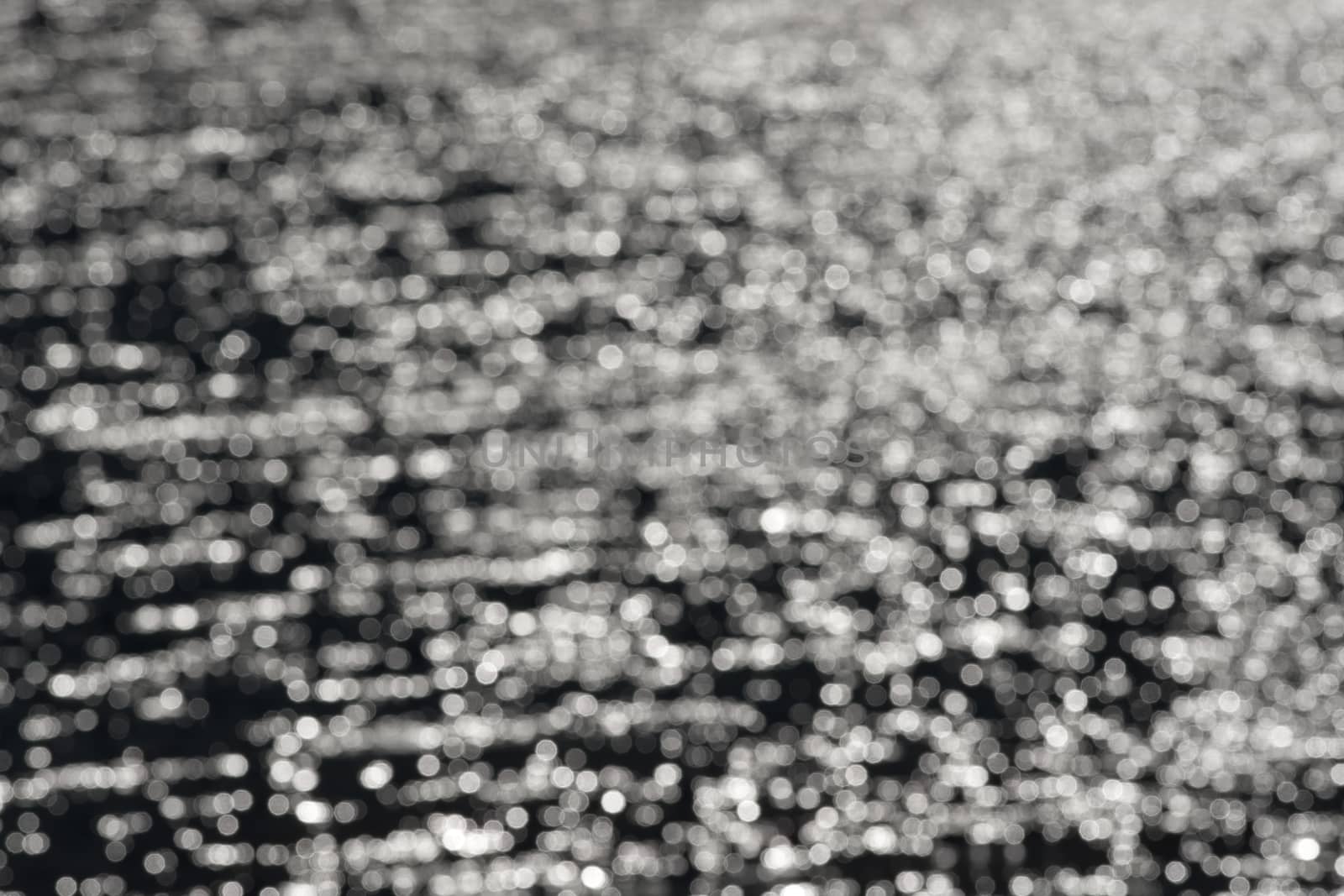 3 - Graduated light to dark bokeh, formed from water ripples and sunlight, giving an abstract textured monochrome background, black and white.