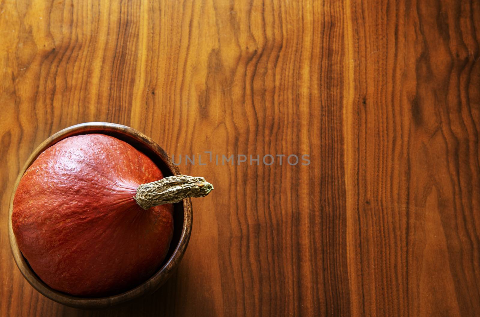 Pumpkin in a bowl on a wooden desk by fyletto