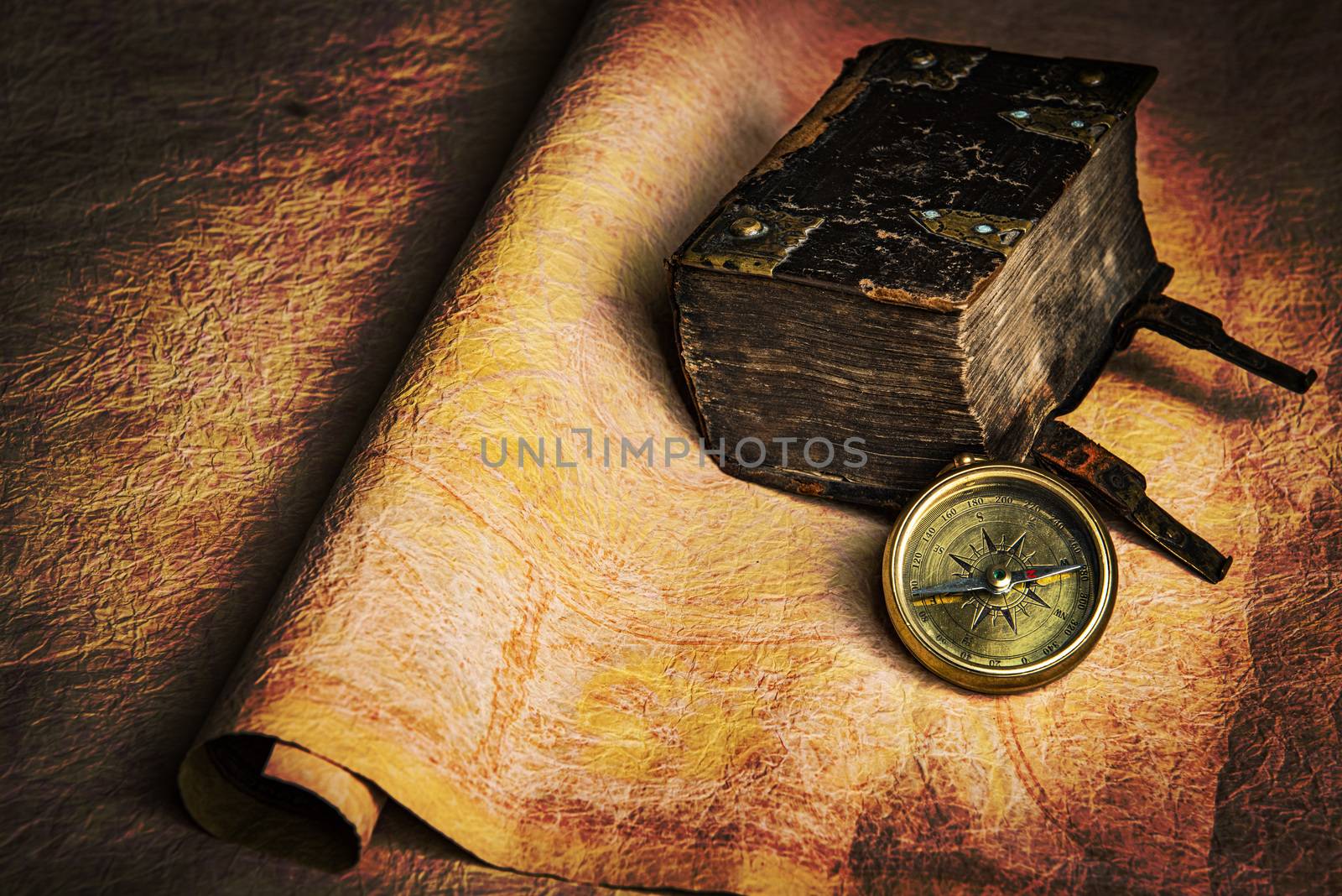 Ancient sailor diary lying together with brass compass on an old grungy parchment. Still life good for navigation or pirate topics