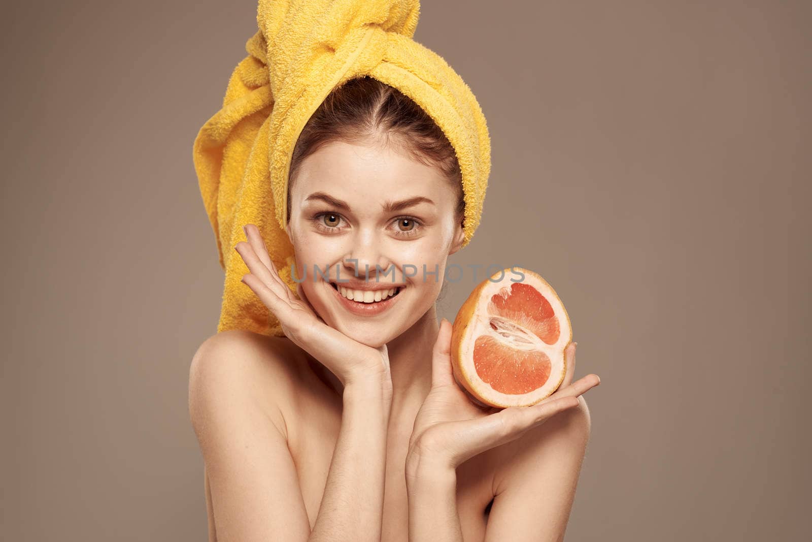 Pretty woman bared shoulders grapefruit in hand natural cosmetics vitamins. High quality photo