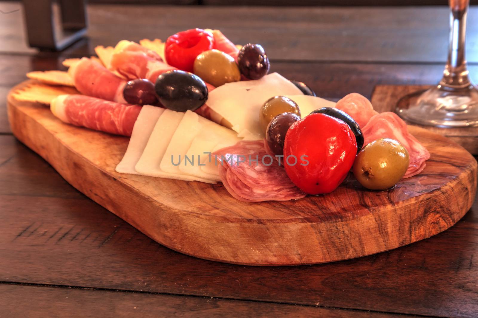 Charcuterie board on rustic wood with candles behind a spread of by steffstarr