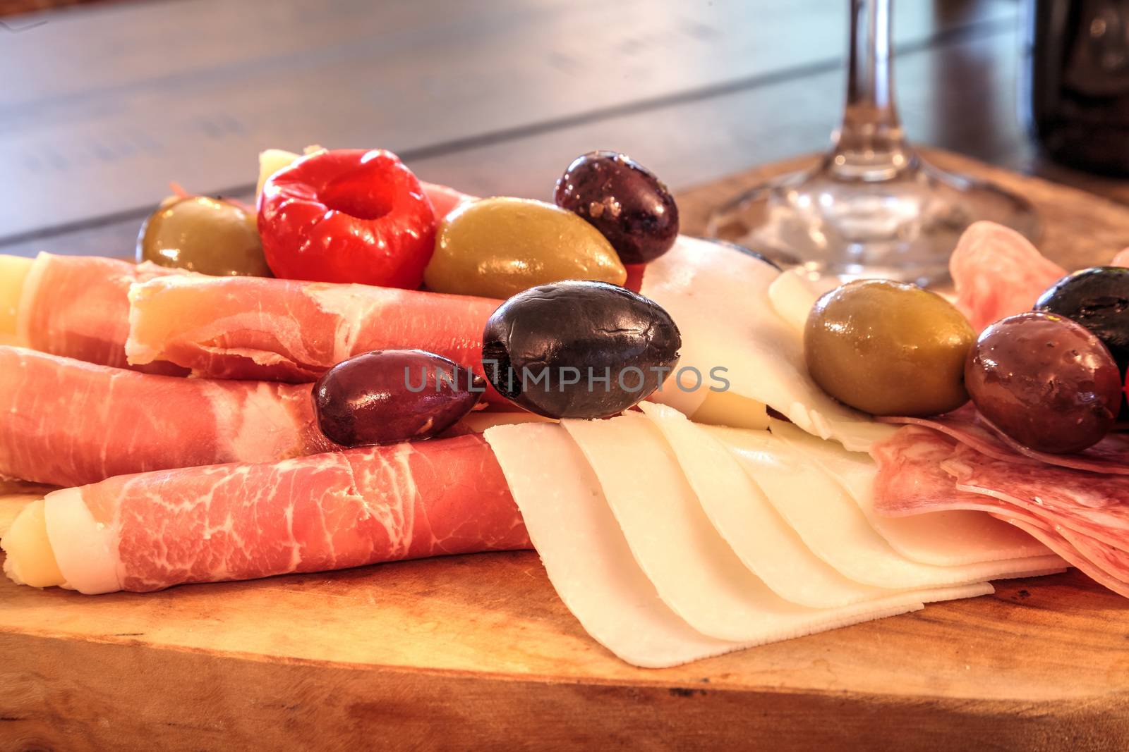 Charcuterie board on rustic wood with candles behind a spread of by steffstarr