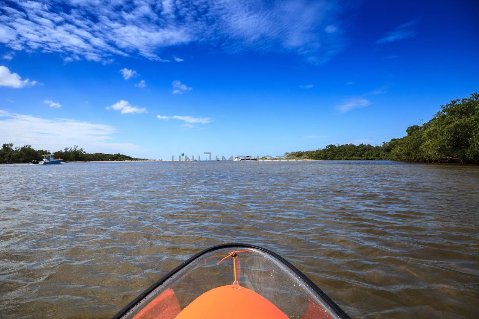 Clear see-through kayak forges its way through the waters of Delnor-Wiggins pass in Bonita Springs, Florida.