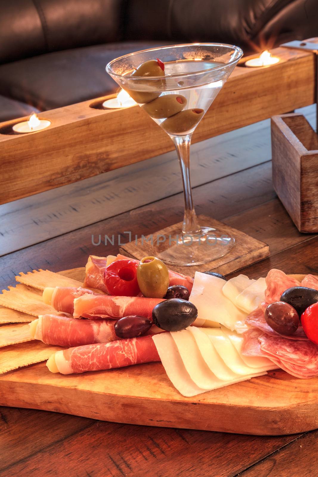 Martini with olives and a Charcuterie board on rustic wood with by steffstarr