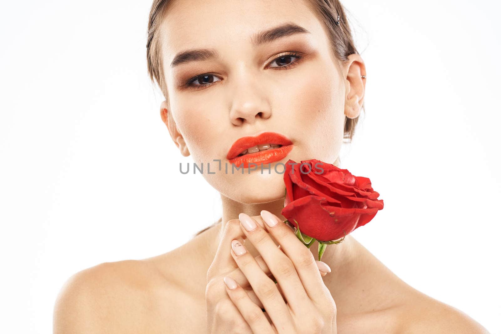 charming brunette girl with makeup on her face and a red rose in her hand. High quality photo