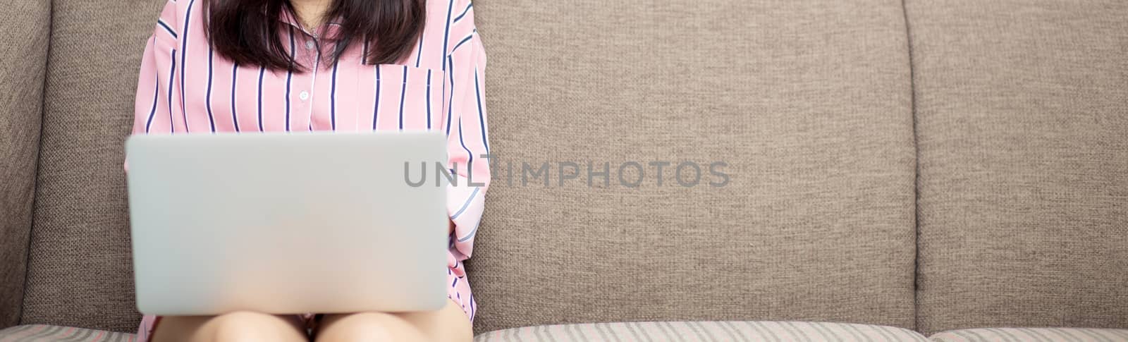 Banner website asian woman working online laptop sitting on couc by nnudoo