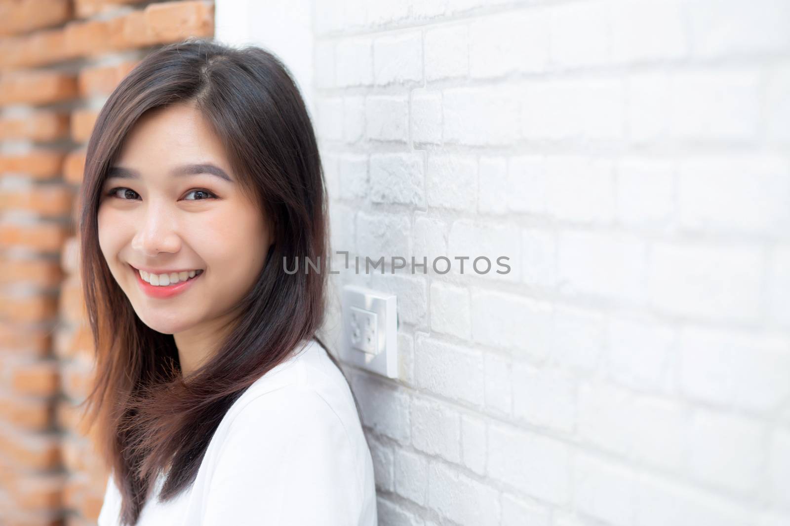 Portrait of beautiful young asian woman happiness standing on gray cement texture grunge wall brick background, businesswoman is a smiling on concrete, business people concept.