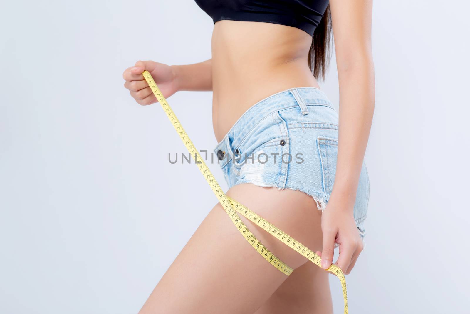Closeup caucasian leg slim and body of woman with measure isolated on white background, girl with measuring centimeter  tape for healthy and diet, cellulite and calories for health care with perfect.
