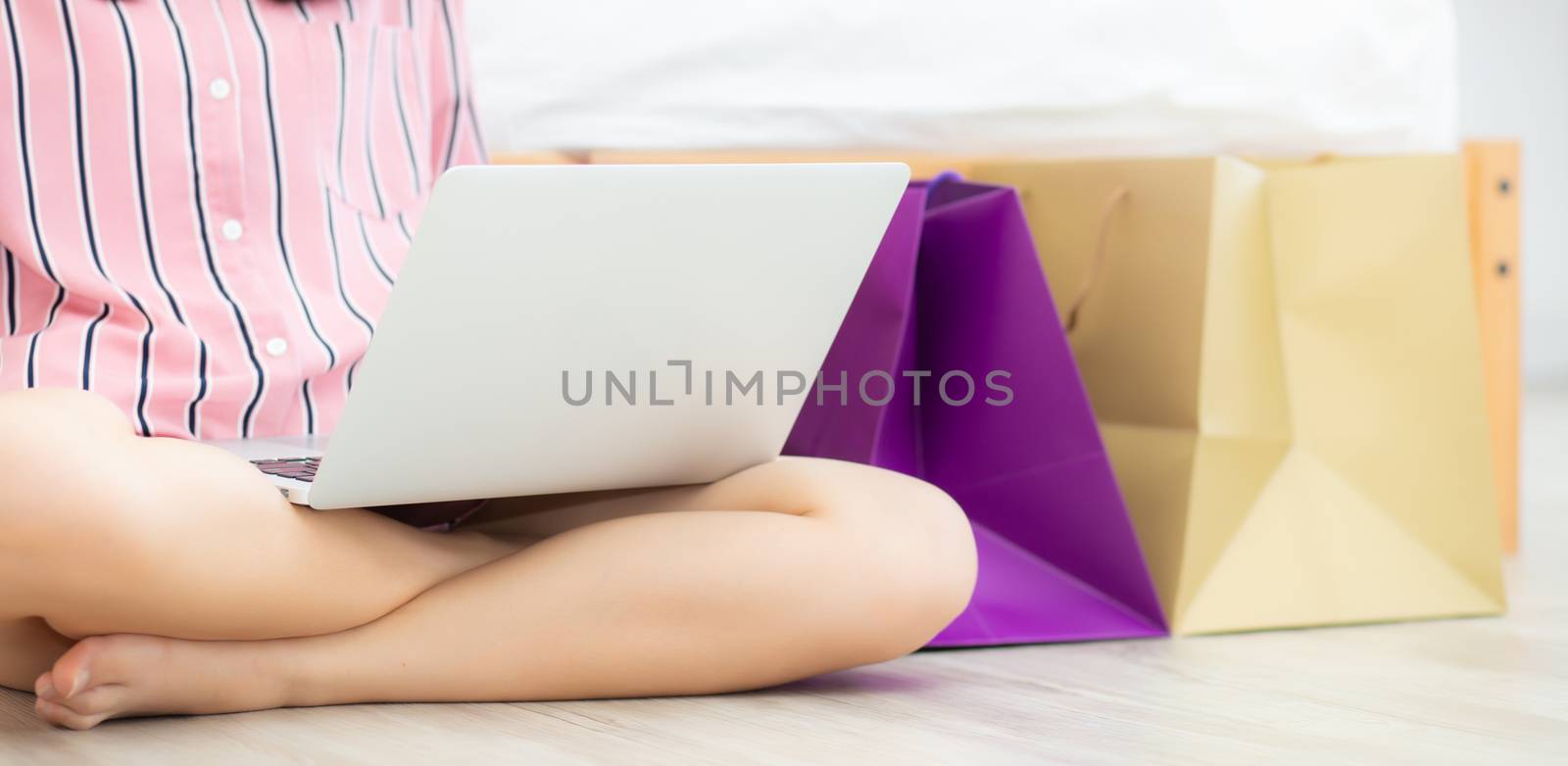 Banner website asian woman shopping online with laptop computer sitting on floor on room, girl holding credit card purchase and shopping bags, lifestyle concept.