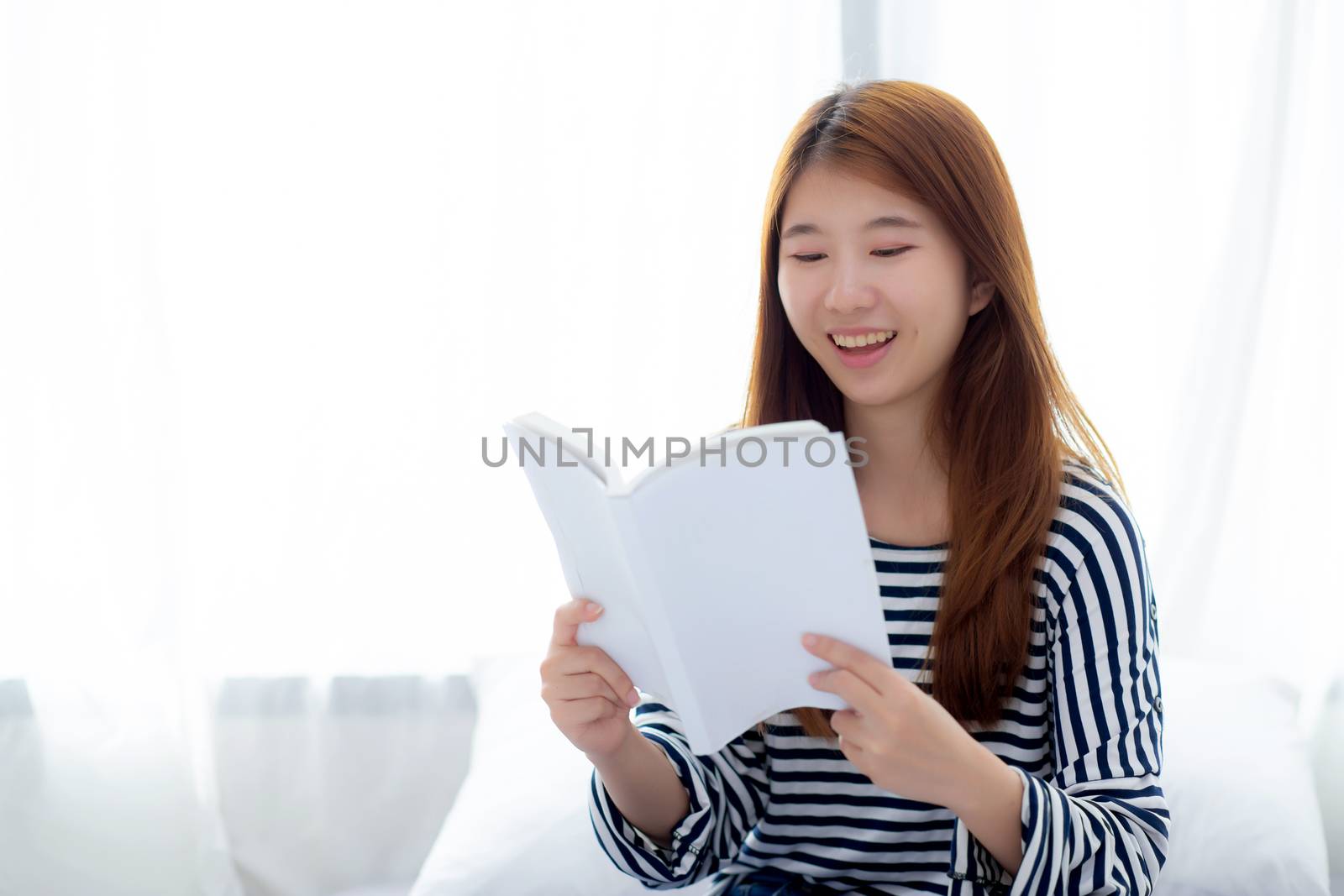 Beautiful of portrait young asian woman relax sitting reading book on bedroom at home, girl study literature, education and llifestyle concept.