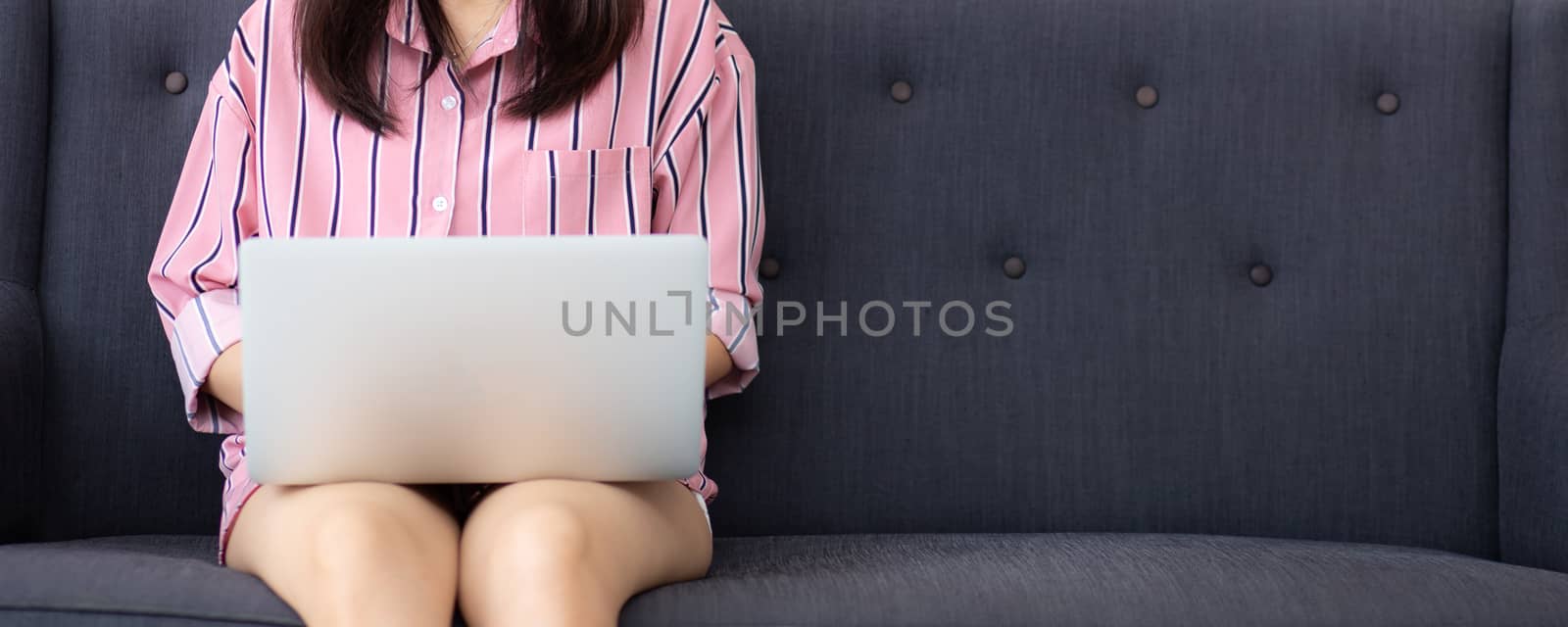 Banner website woman working online laptop sitting on sofa at living room, girl using notebook computer with connect to internet for distance job, business and success concept.