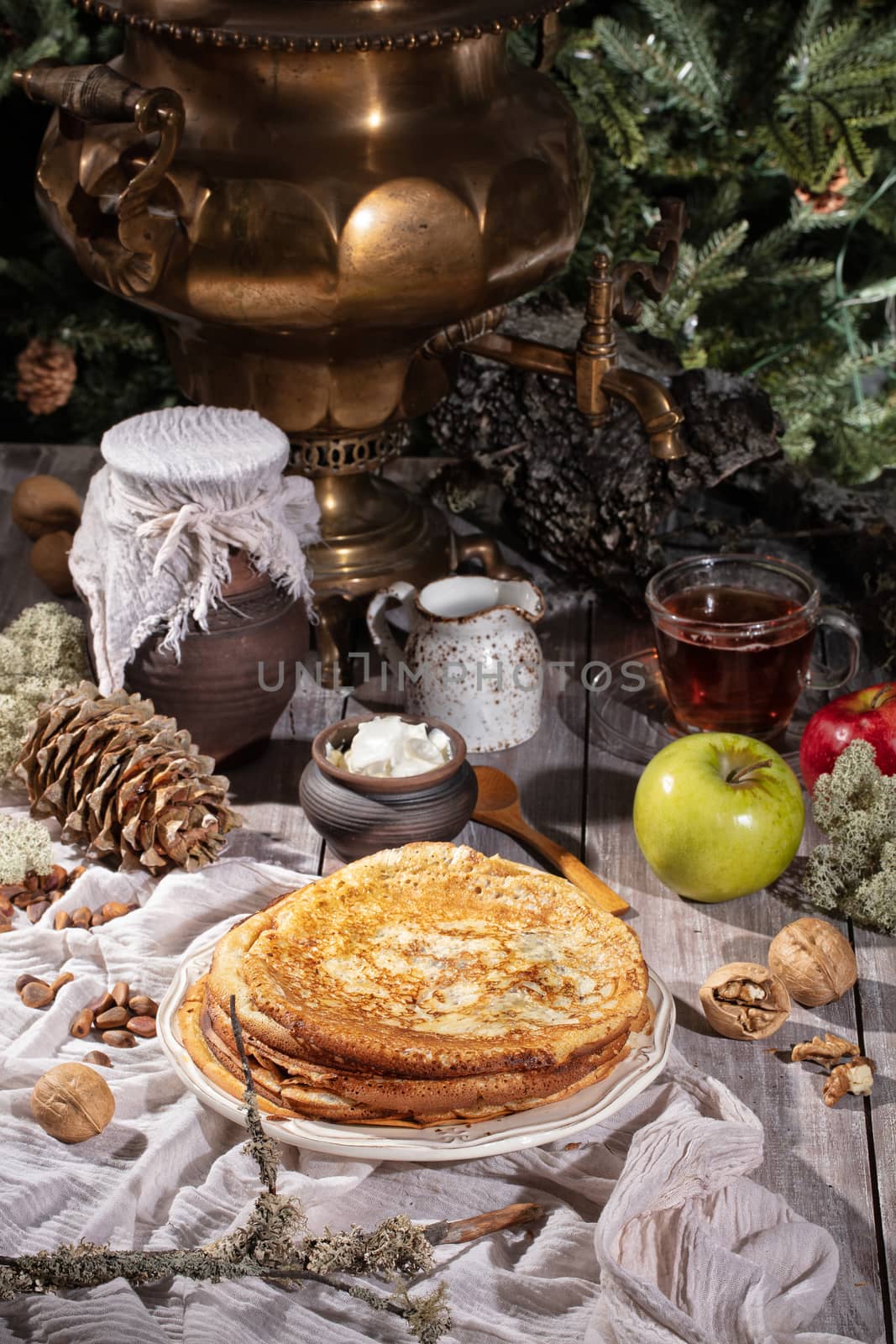 Pancakes, tea, cream and fruits on a fabric background