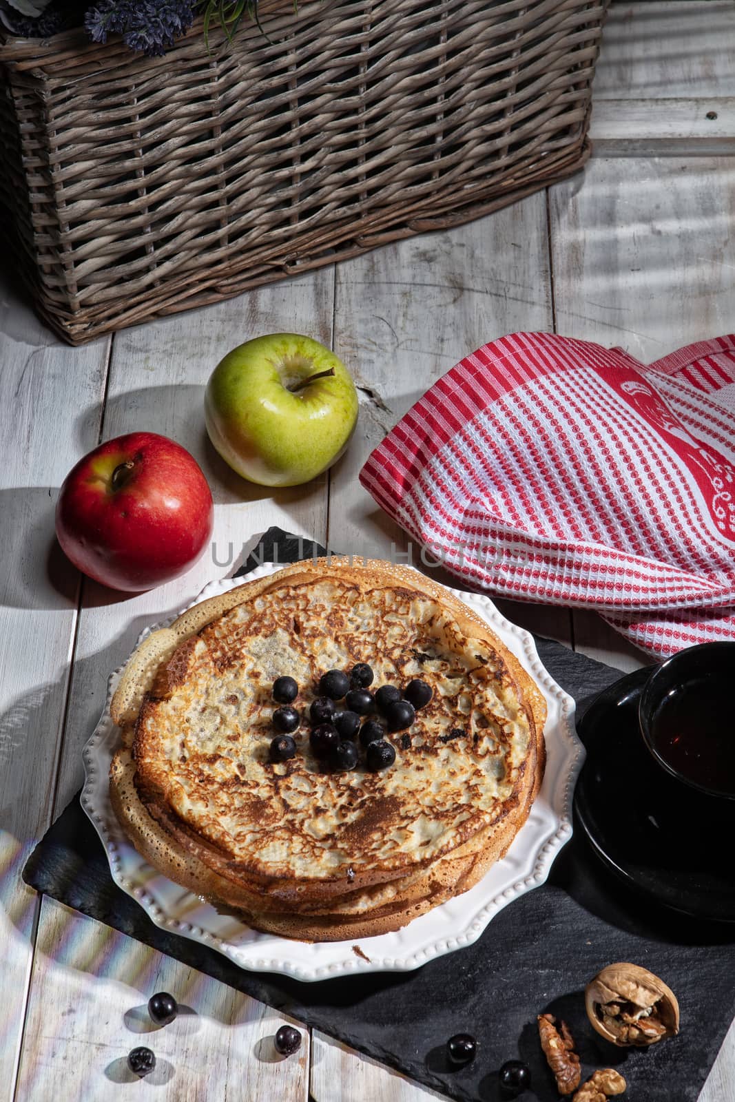 Pancakes, tea, cream and fruits on a fabric background