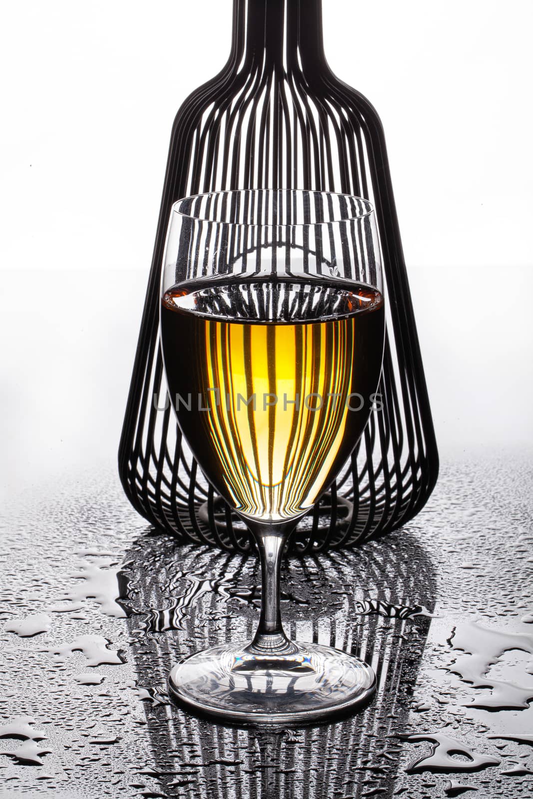 Glass of white wine and shape on a glass background