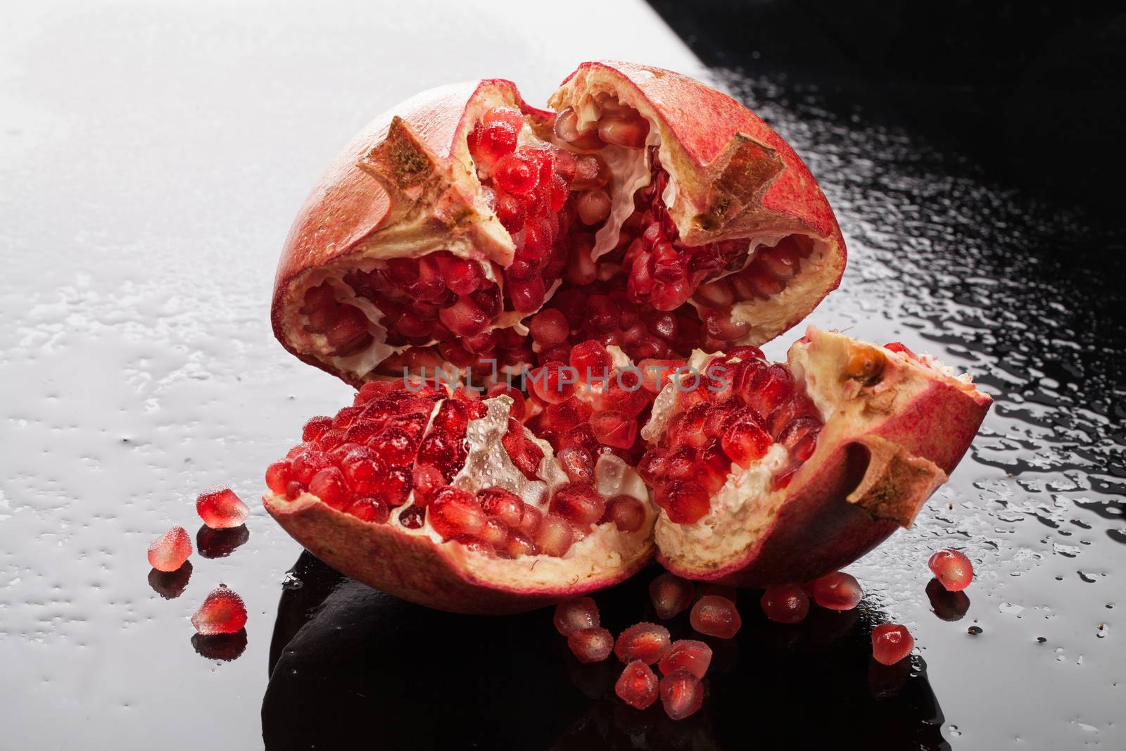 Pomegranate on a glass background with drops of water