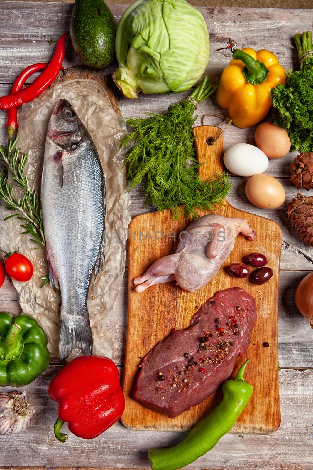 Chicken, fish and vegetables on an old wooden desk