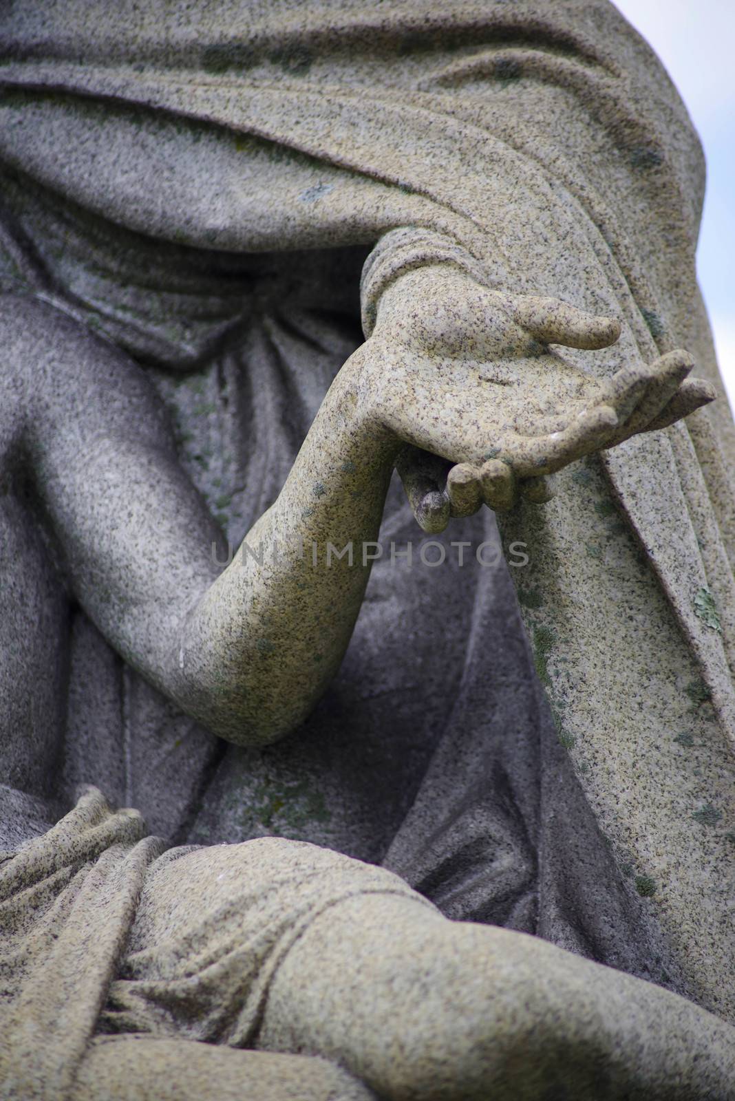 Close up of Mary holding Jesus's hand with stigmata in  cemetery by marysalen