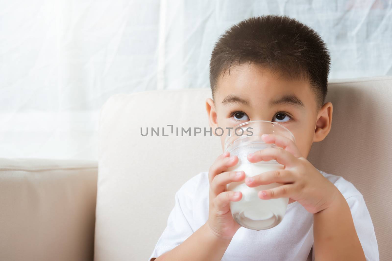 Little child boy hand holding milk glass he drinking white milk by Sorapop