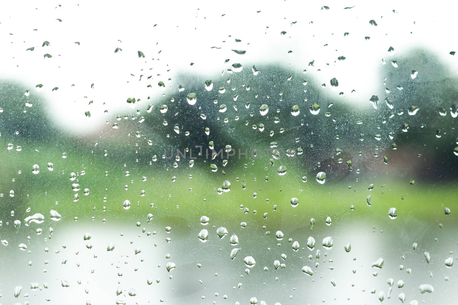 Rain drop on glass window background. by kaisorn
