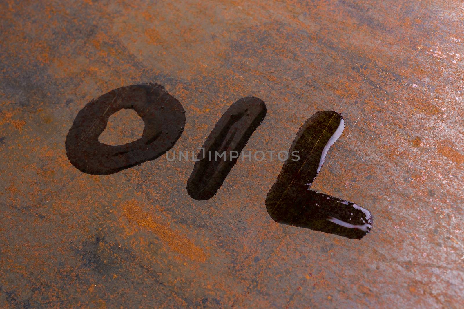 handwritten word oil on rusted sheet metal surface - close-up with selective focus conceptual photography