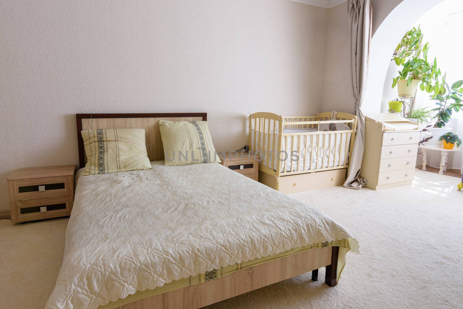 Bedroom interior, adult bed, newborn crib and changing table nearby