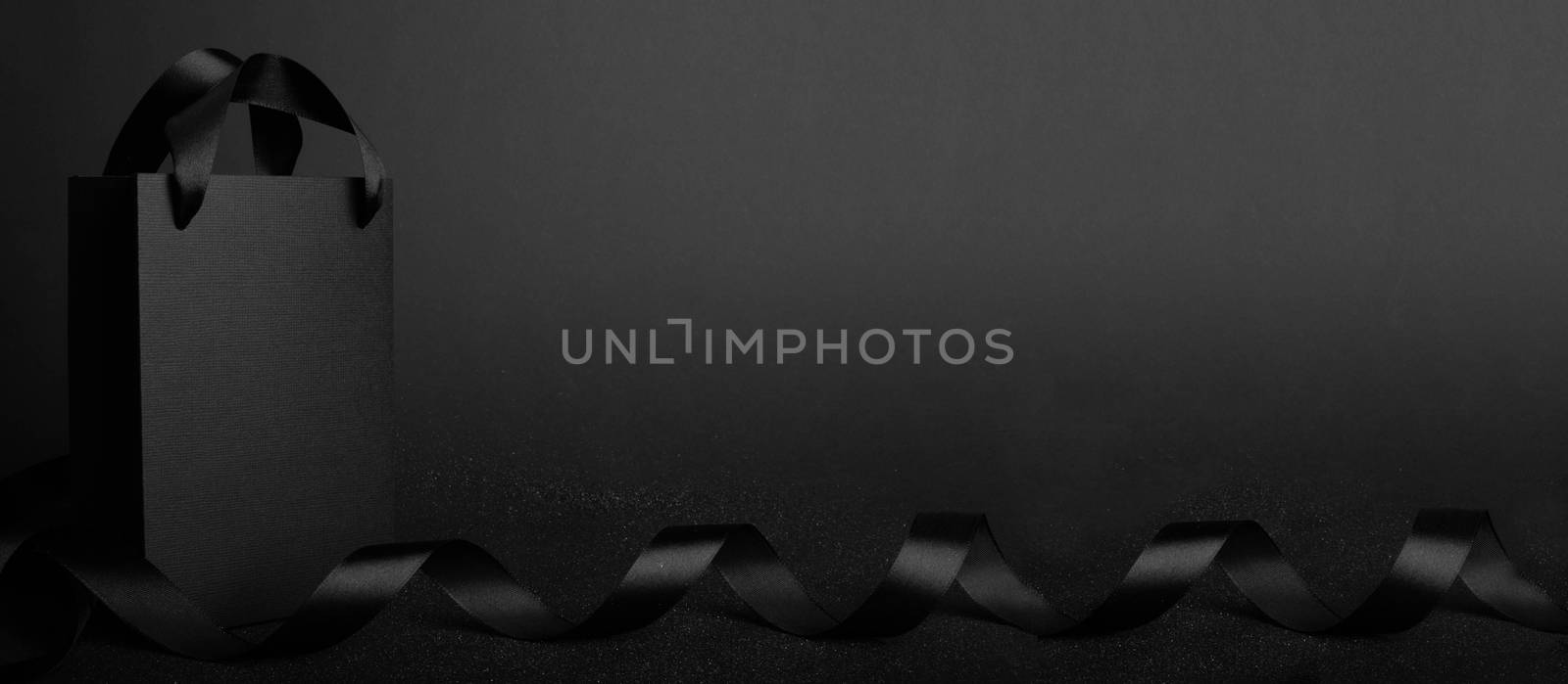 Black Friday blank empty paper bag with copy space for text and logo on dark background sale concept banner backgrounds