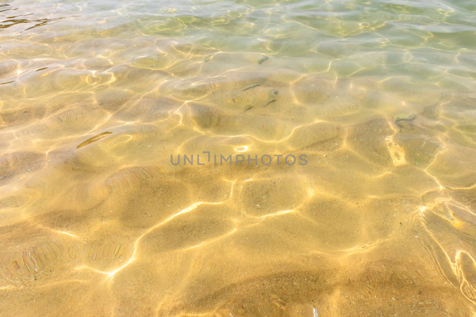 Ripples of water waves reflecting texture on a sandy beach bottom