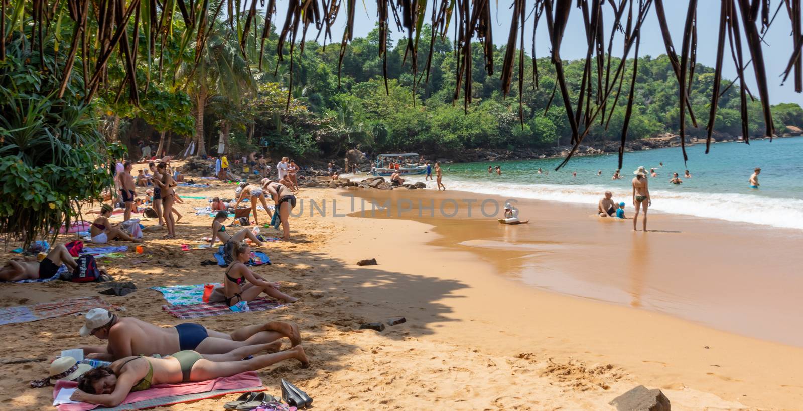 people sunbathing in Rumassala South Beach, is situated along with the Rumassala hill in Unawatuna. It is also known as Jungle Beach