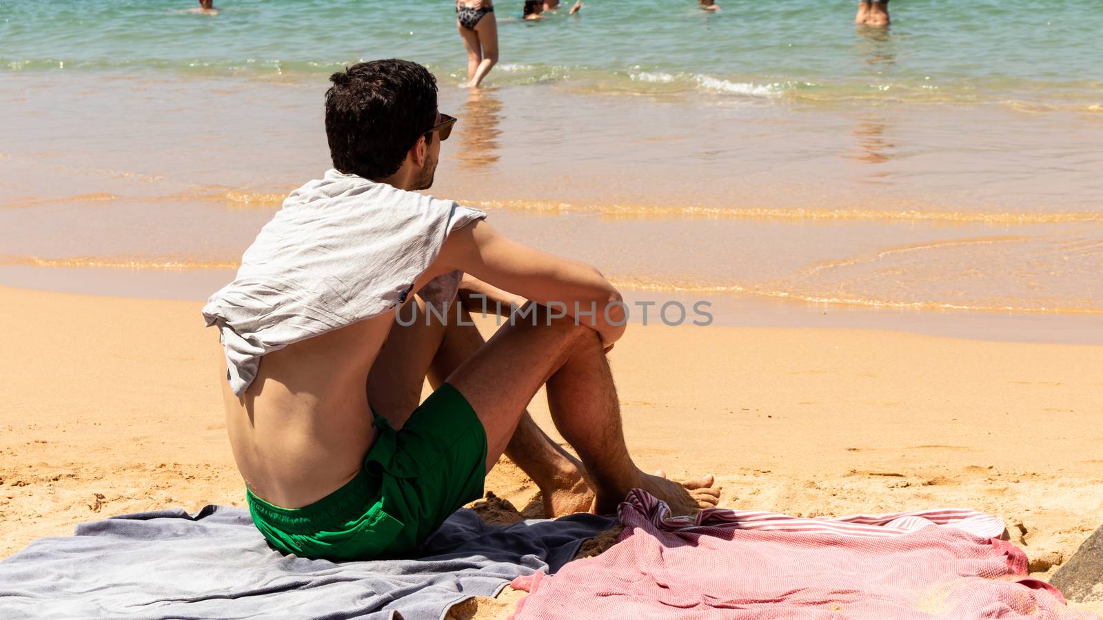 Young male sunbathing and enjoying the view in the picturesque beach by nilanka