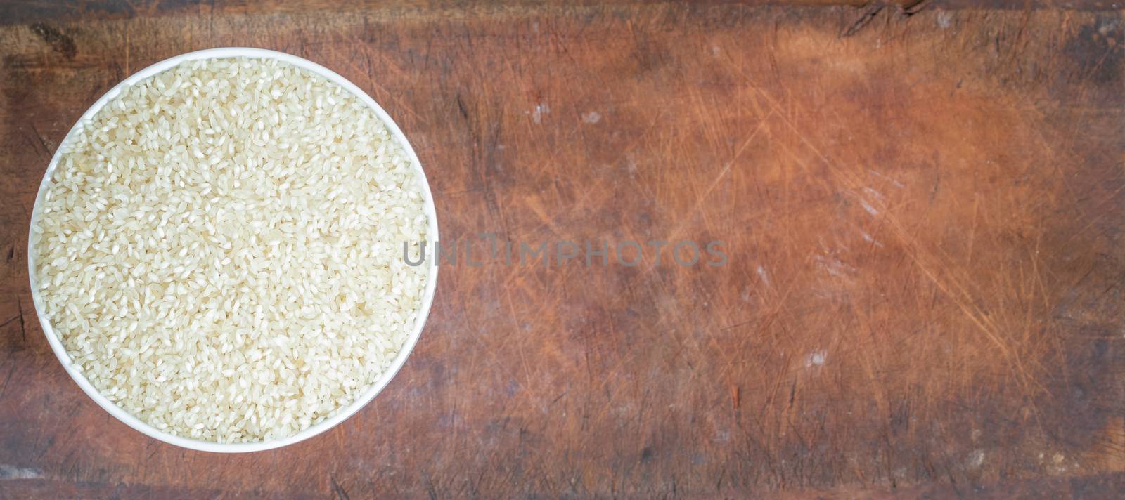 Bowl of white Rice on wooden board by nilanka