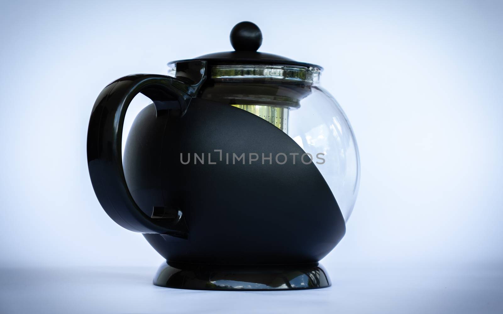 Black glass coffee pot in neutral background angled side view by nilanka