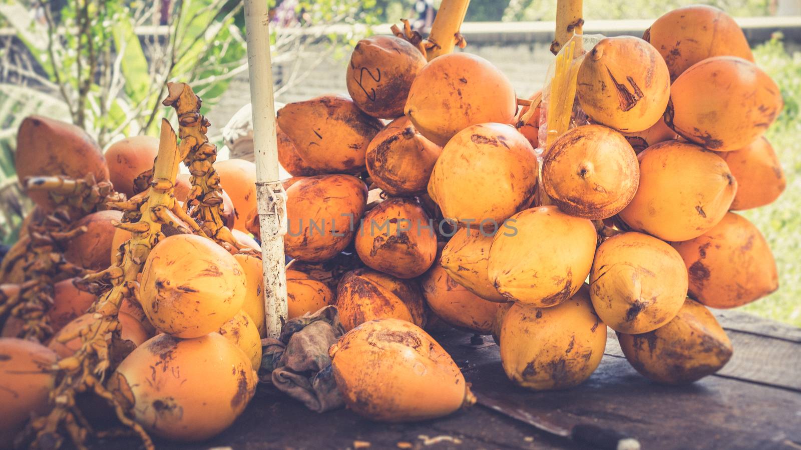 King coconut bunch on a table with a knife by nilanka