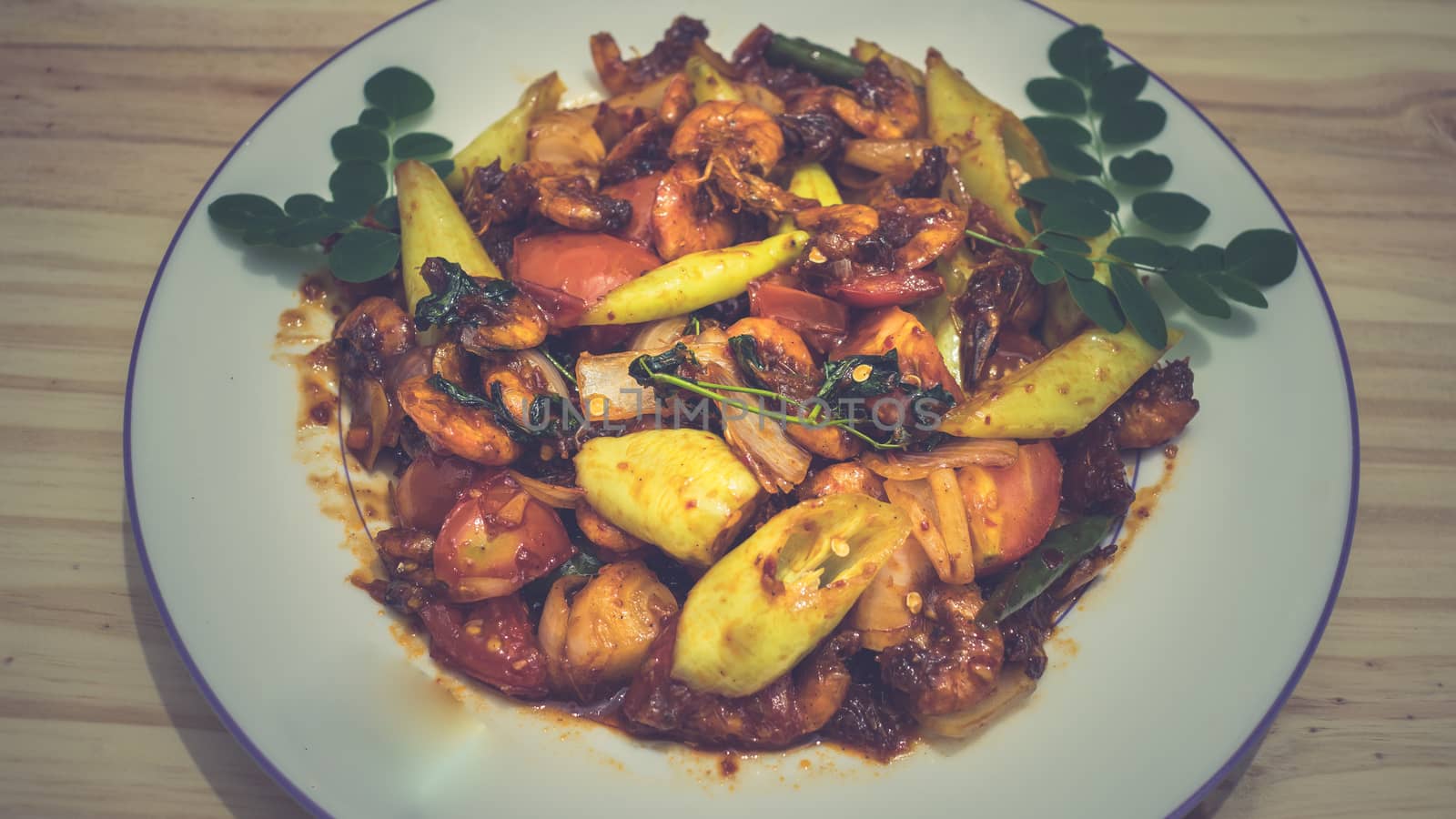 Plate of deviled prawns on a dinner table by nilanka