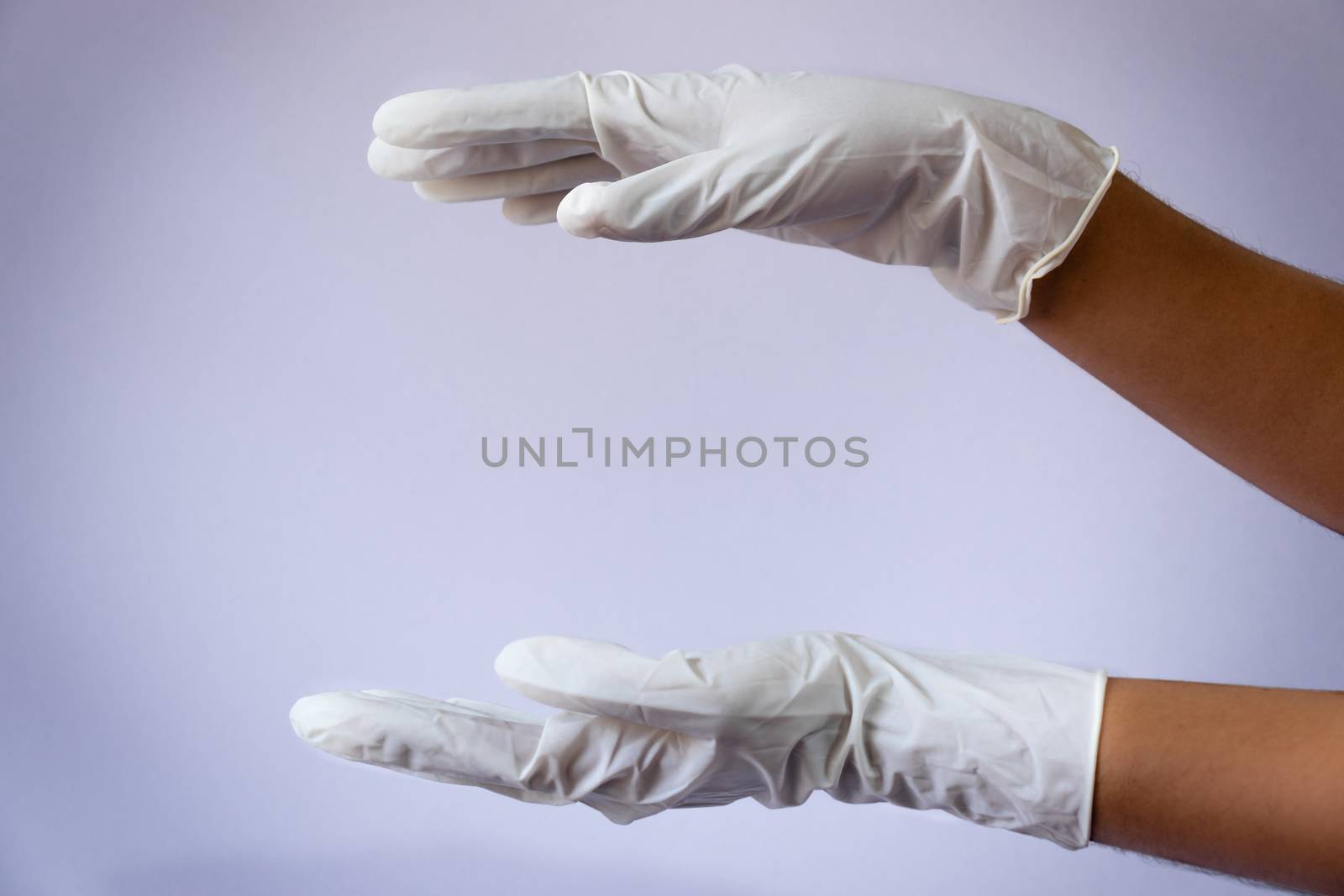 Female doctor wearing medical latex gloves in both hands by nilanka