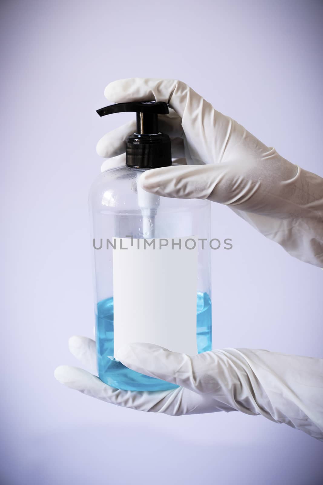 Presenting sanitizer bottle by both hands with medical latex gloves