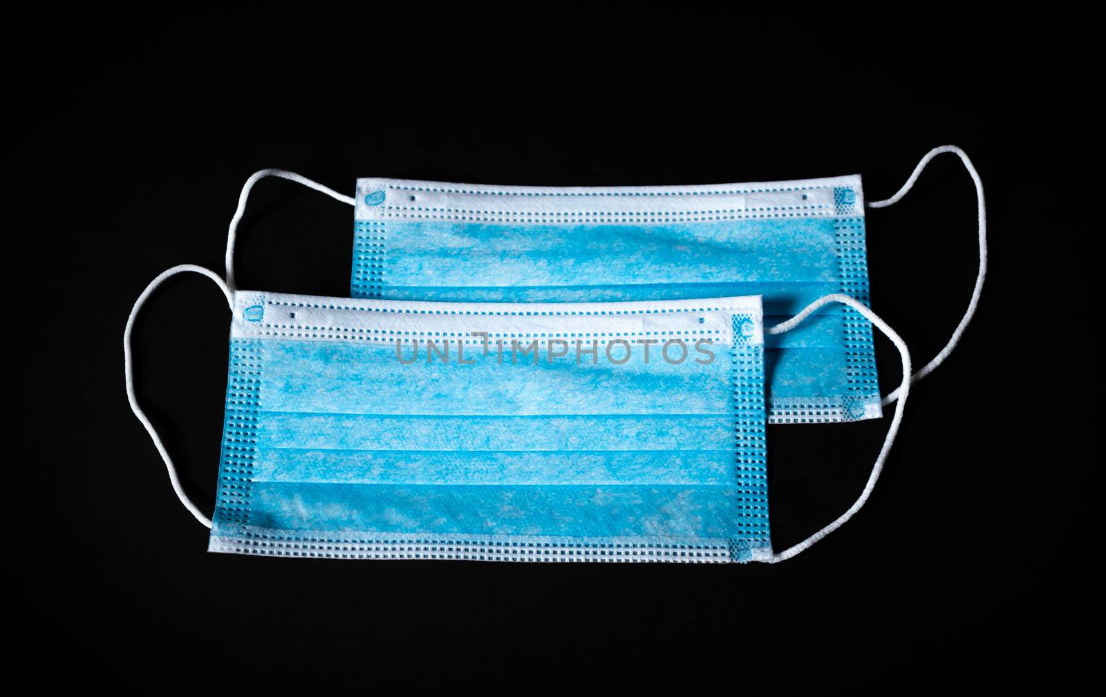 Two Surgical Face Masks in black background