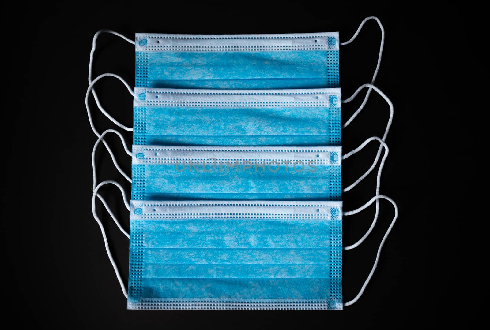 Four Medical Face Masks lined up in black background