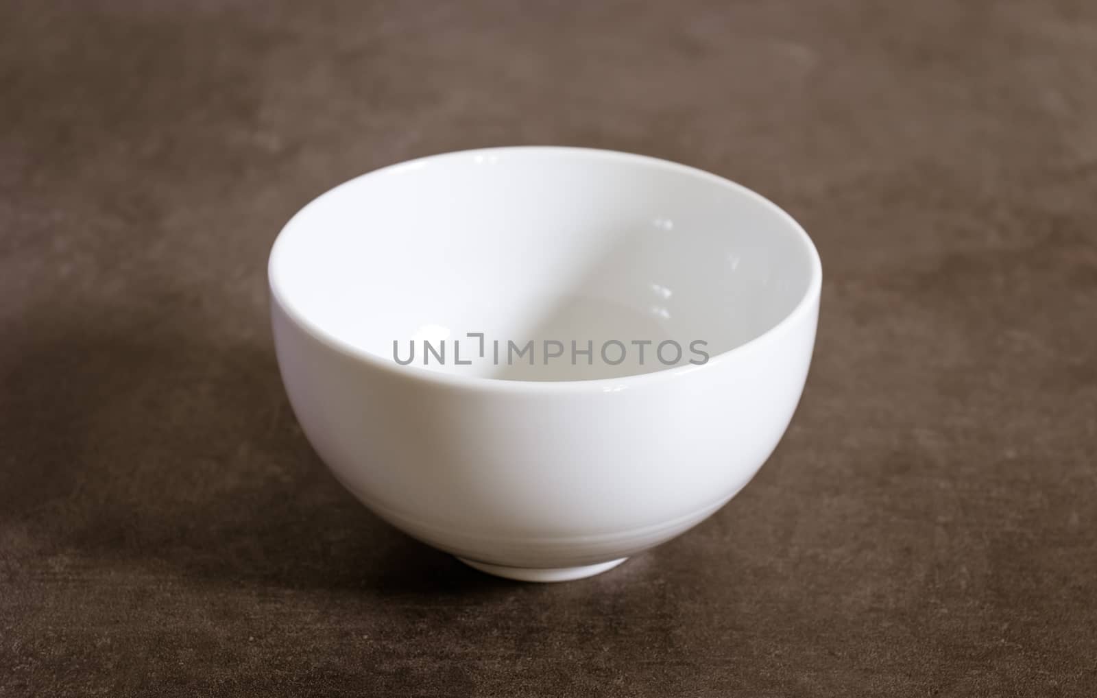 Empty polished white Ceramic bowl on a table by nilanka