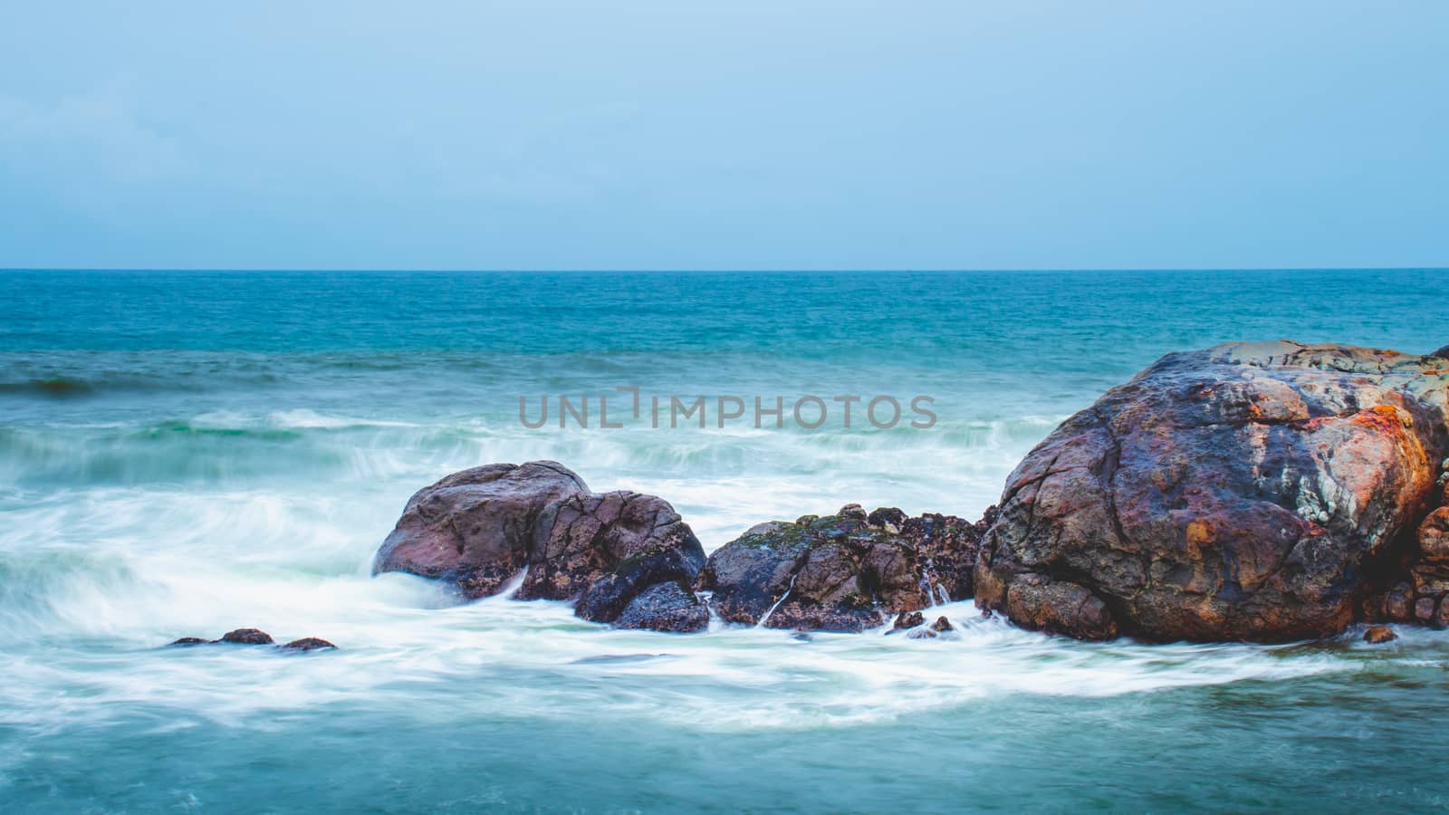 Long Exposure Ocean Waves hitting collection of rocks by nilanka