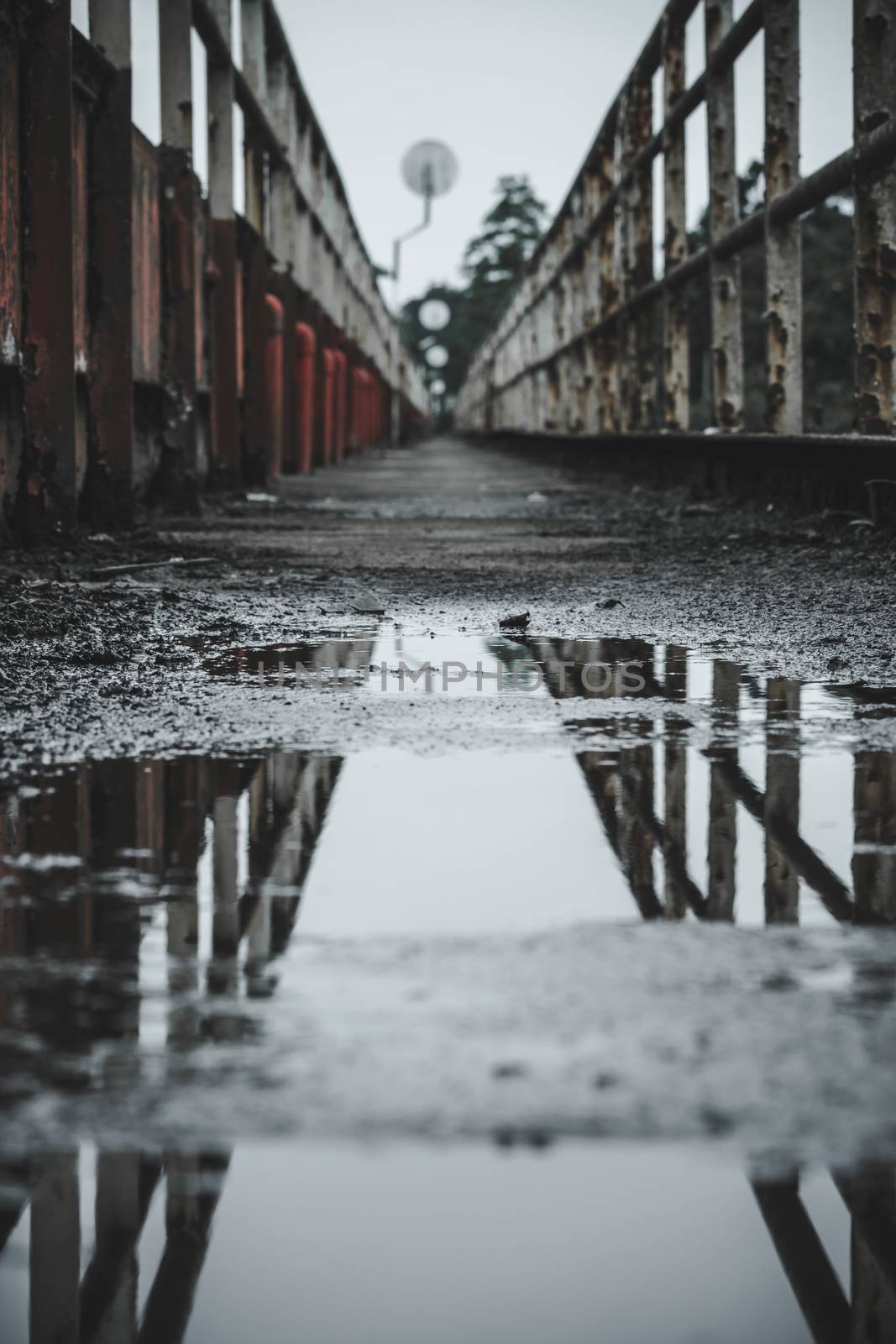 Water puddle reflection on a pedestrian Walking bridge by nilanka