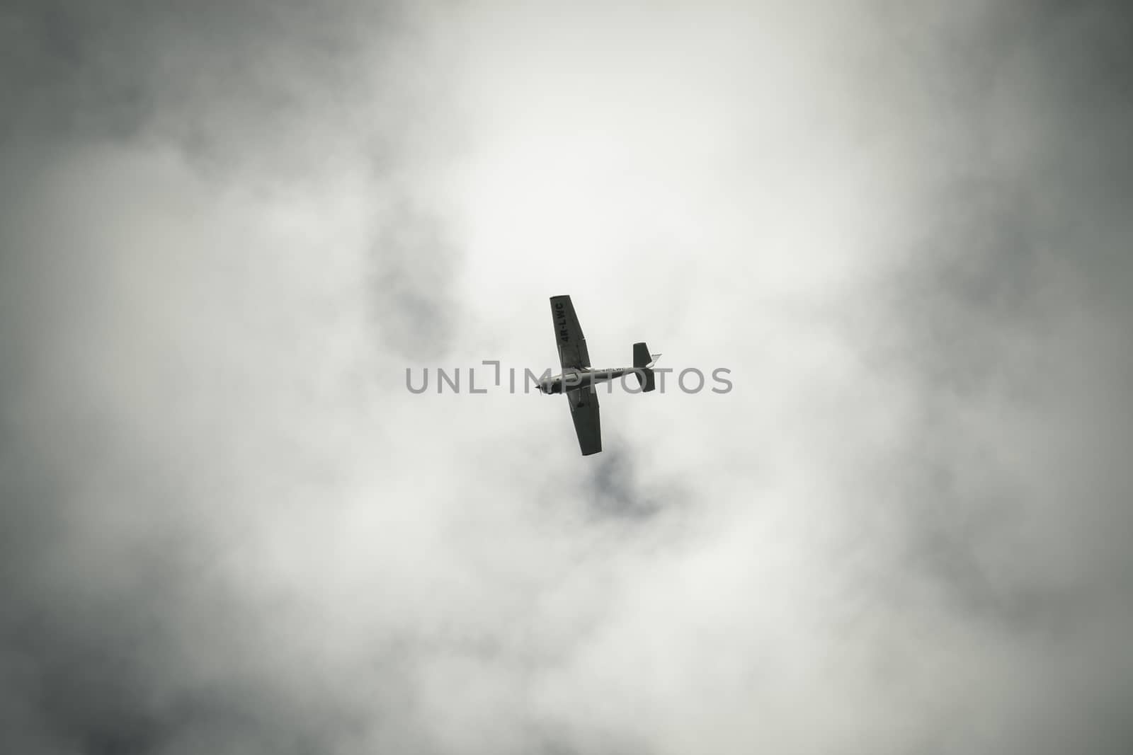 Air Plane seen from the ground long distance against dark clouds
