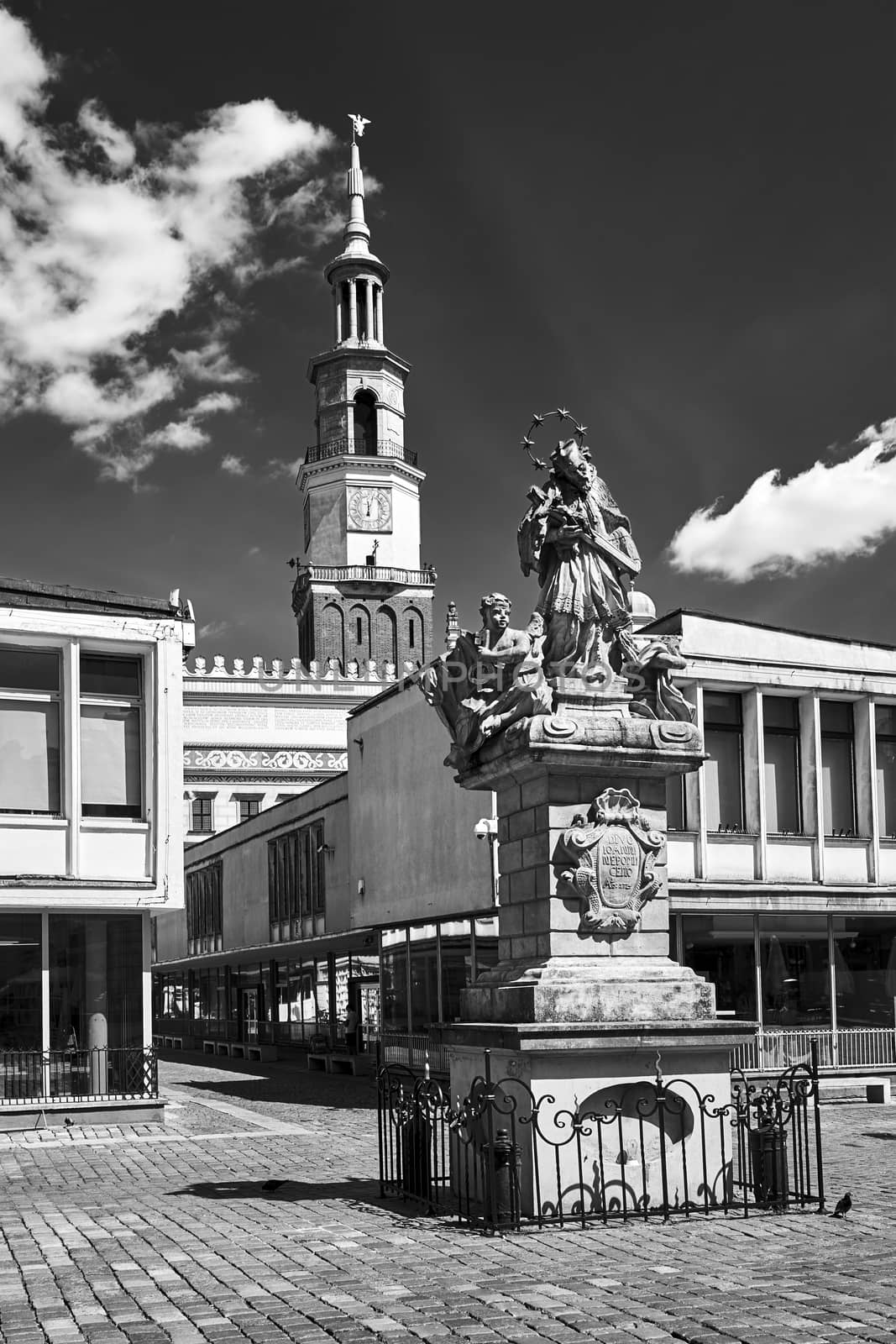 The historic figure of St. John of Nepomuk and the town hall tower in the market square in Poznan, monochrome