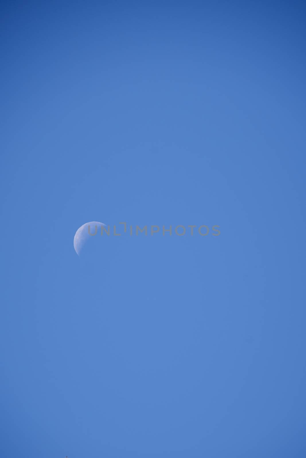 Crescent moon over cloudless, blue, blue sky, sunny
