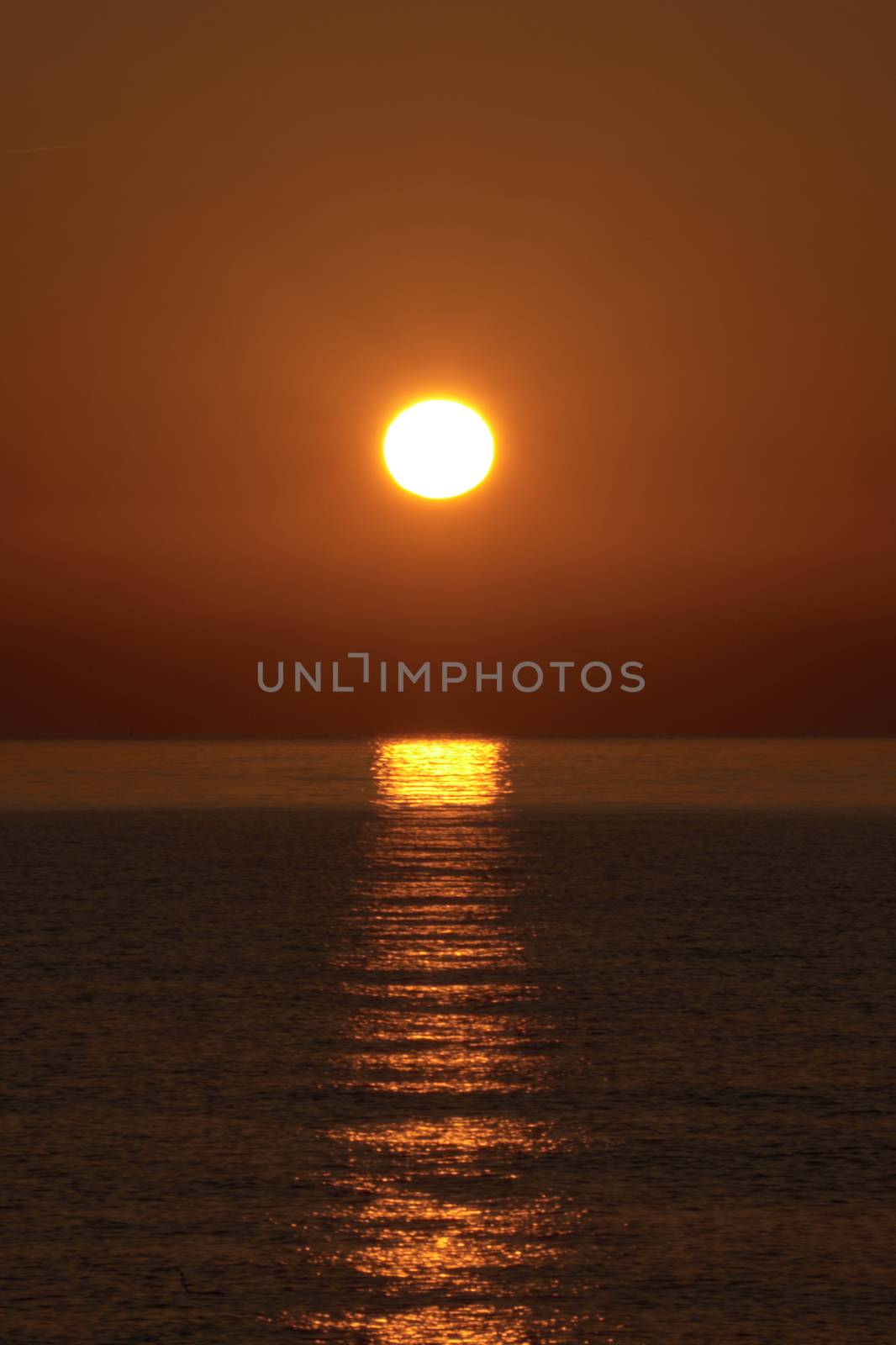 Sunrise on the beach, sun on the water, orange, reflections