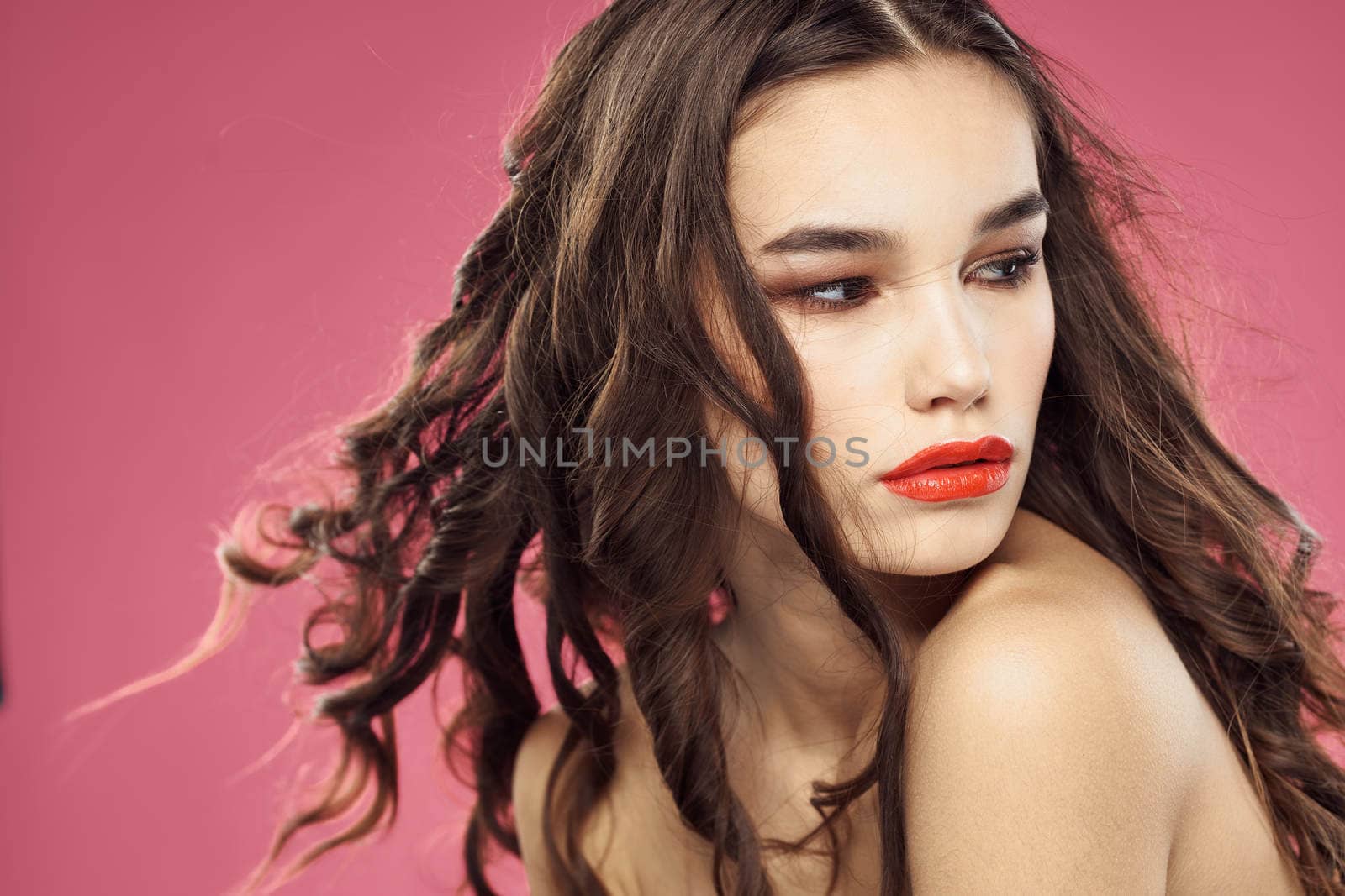 Attractive woman fashionable hairstyle bared shoulders and red lips pink background by SHOTPRIME