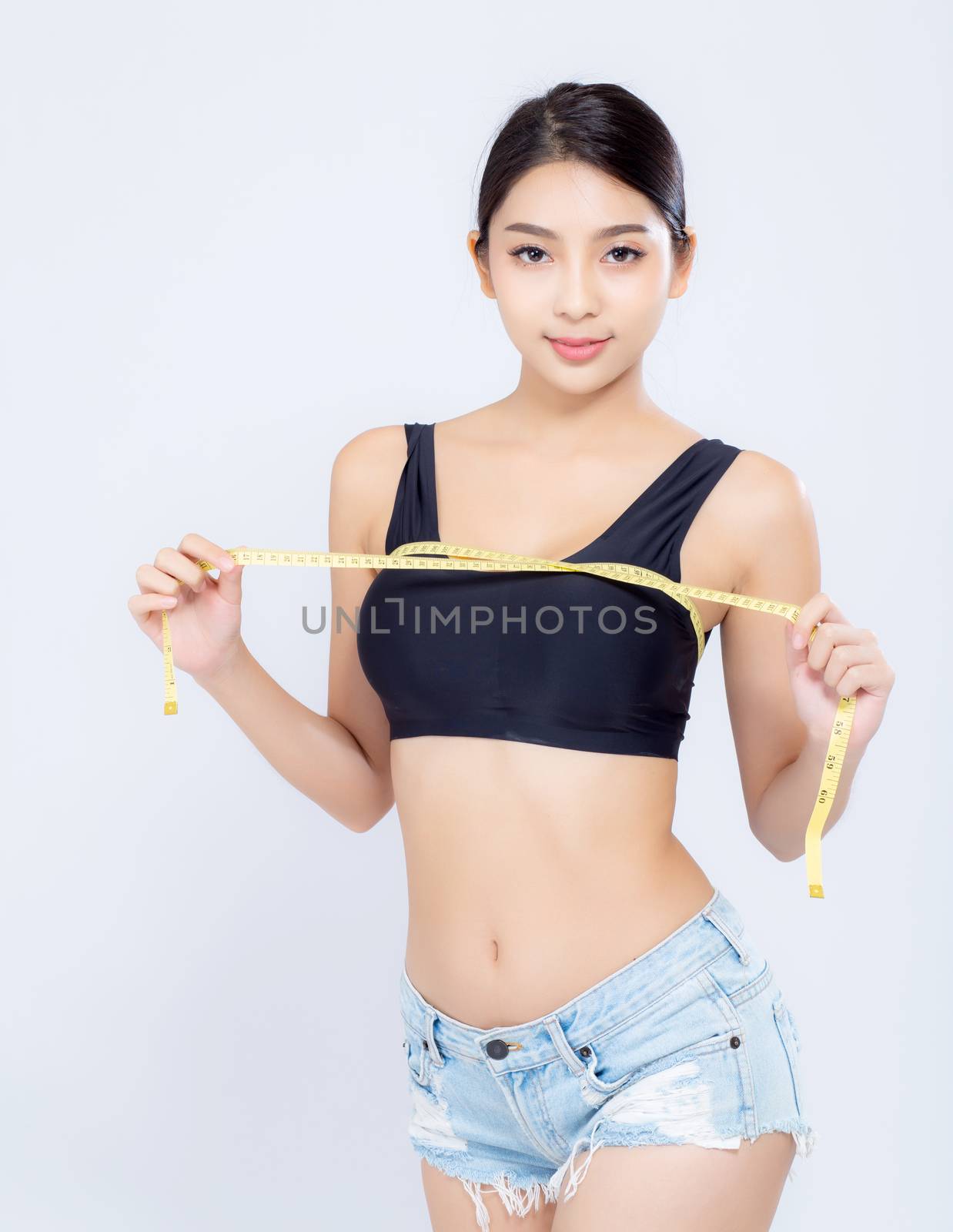 Beautiful portrait asian woman diet and slim with measuring breast and augmentation isolated on white background, girl have cellulite loss with tape measure, health and wellness concept.