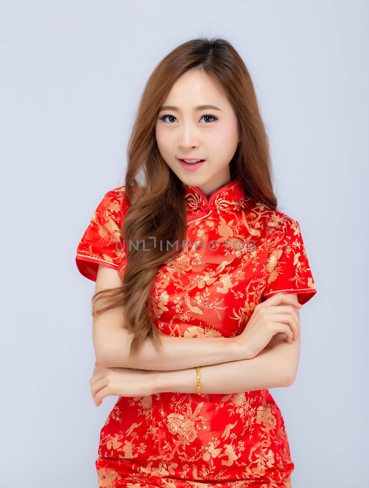 Beautiful portrait happy Chinese New Year young asian woman wear cheongsam smile with gesture congratulation and greeting isolated on white background, festival and celebrate concept.
