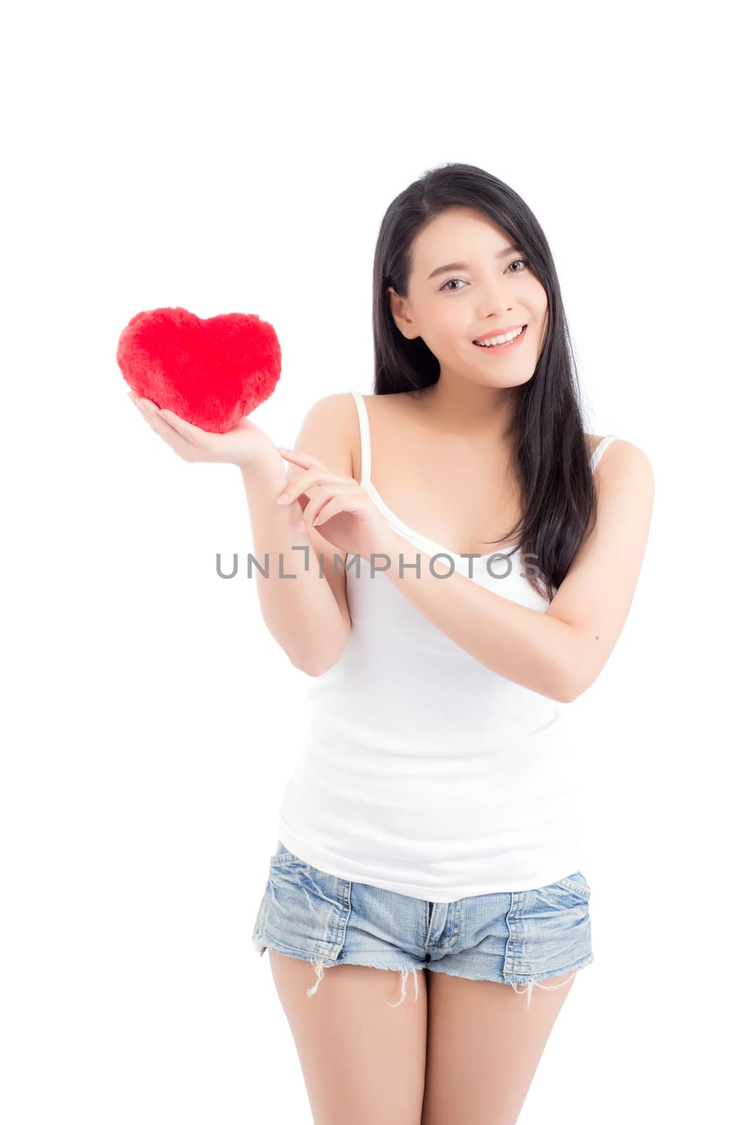 Portrait of beautiful asian young woman holding and pointing red heart shape pillow and smile isolated on white background, valentines day, holiday concept.