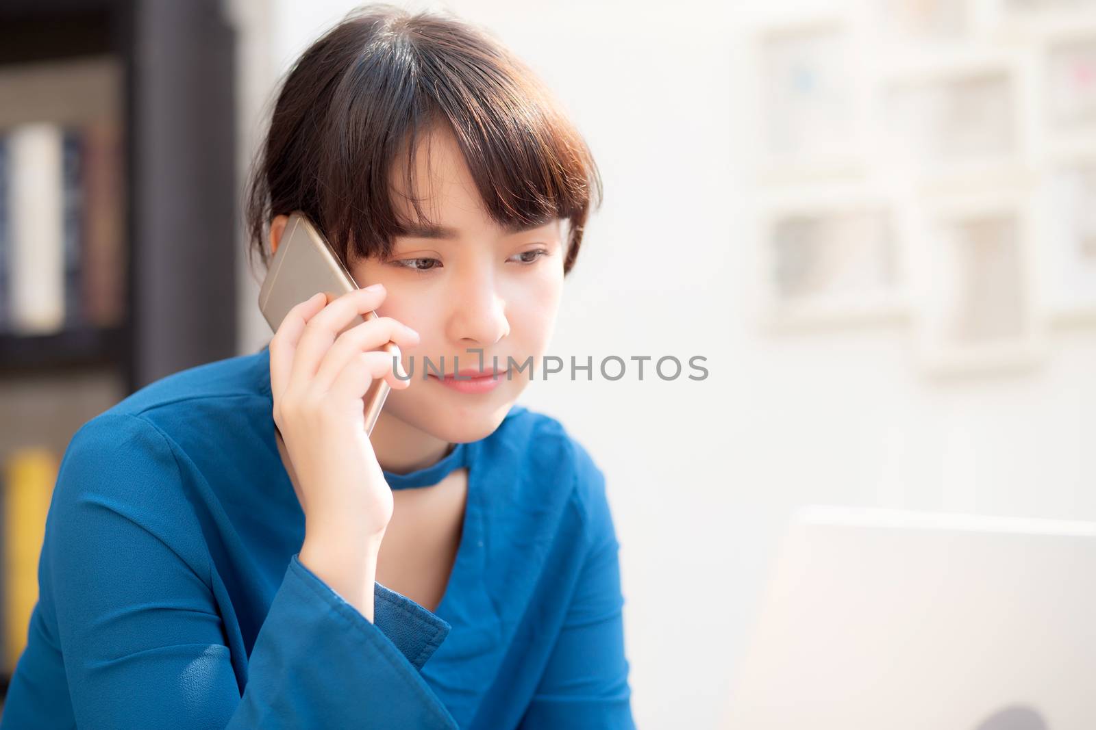 Beautiful asian young businesswoman excited and glad of success work with laptop, girl taking mobile smart phone and working coffee shop, career freelance business concept.